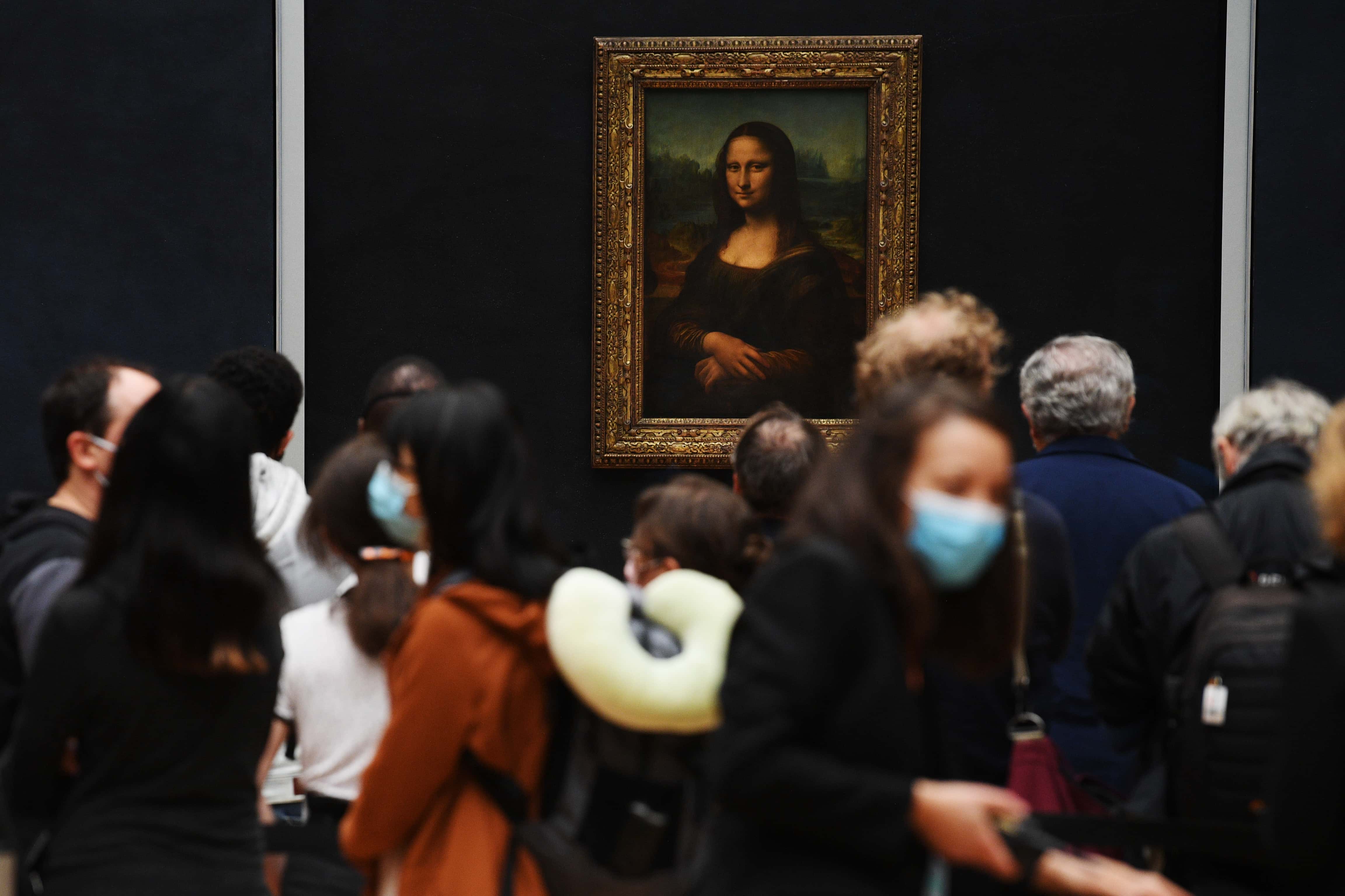 Image Source: Visitors queue observing social distancing marking to see Leonardo da Vinci's 'Mona Lisa' at the Louvre museum as it reopens its doors following its 16 week closure due to lockdown measures caused by the COVID-19 coronavirus pandemic, at the Louvre on July 6, 2020 in Paris, France. (Photo by Pascal Le Segretain/Getty Images)