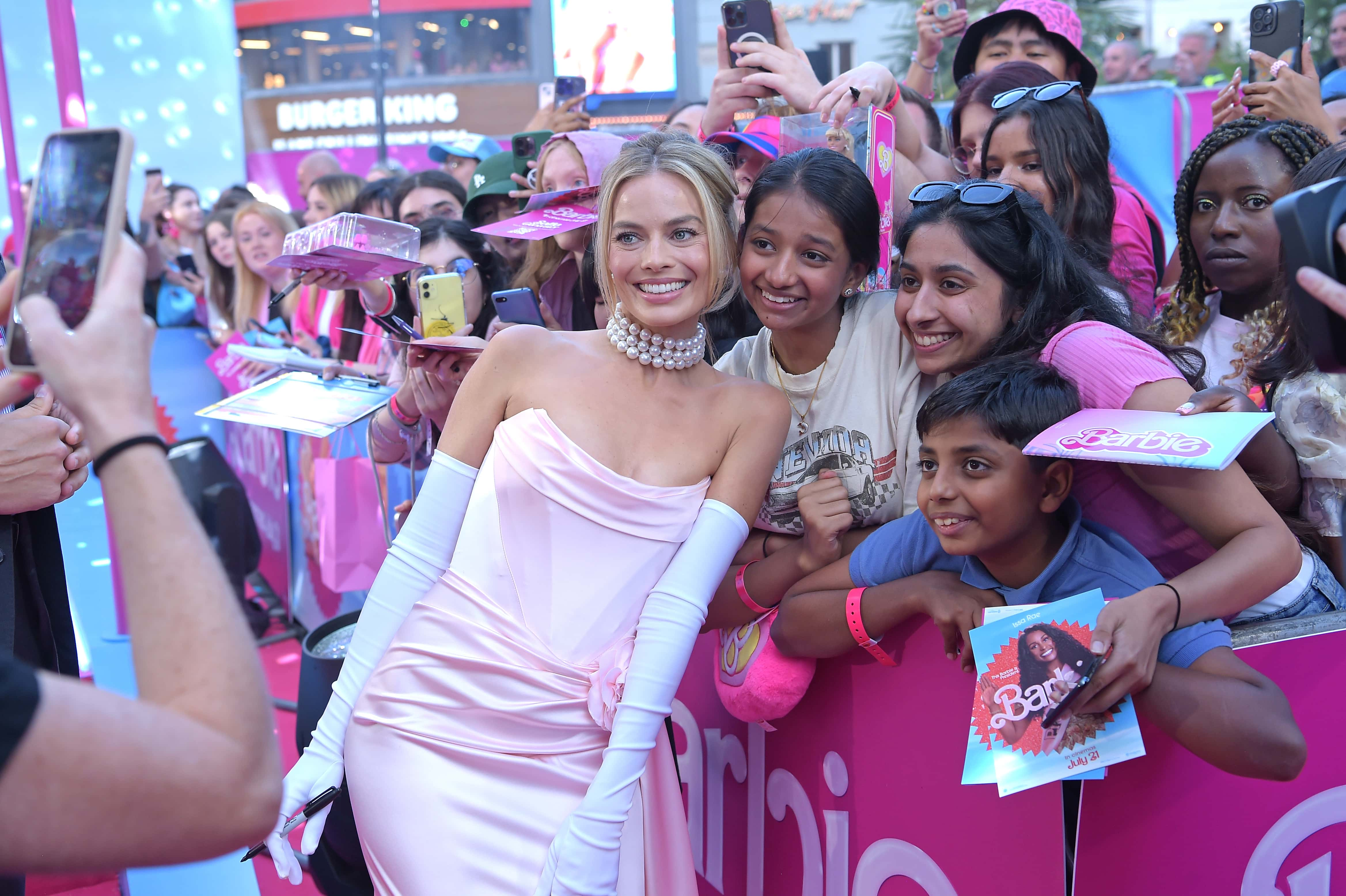 Image Source: Margot Robbie takes a selfie with fans during The European Premiere Of 