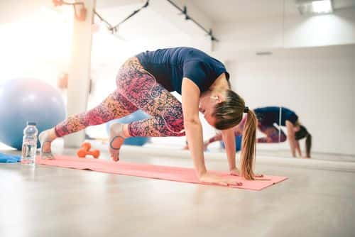 Young Athlete Female in Plank Pose doing Running Abs - Getty Images | AleksandarGeogiev
