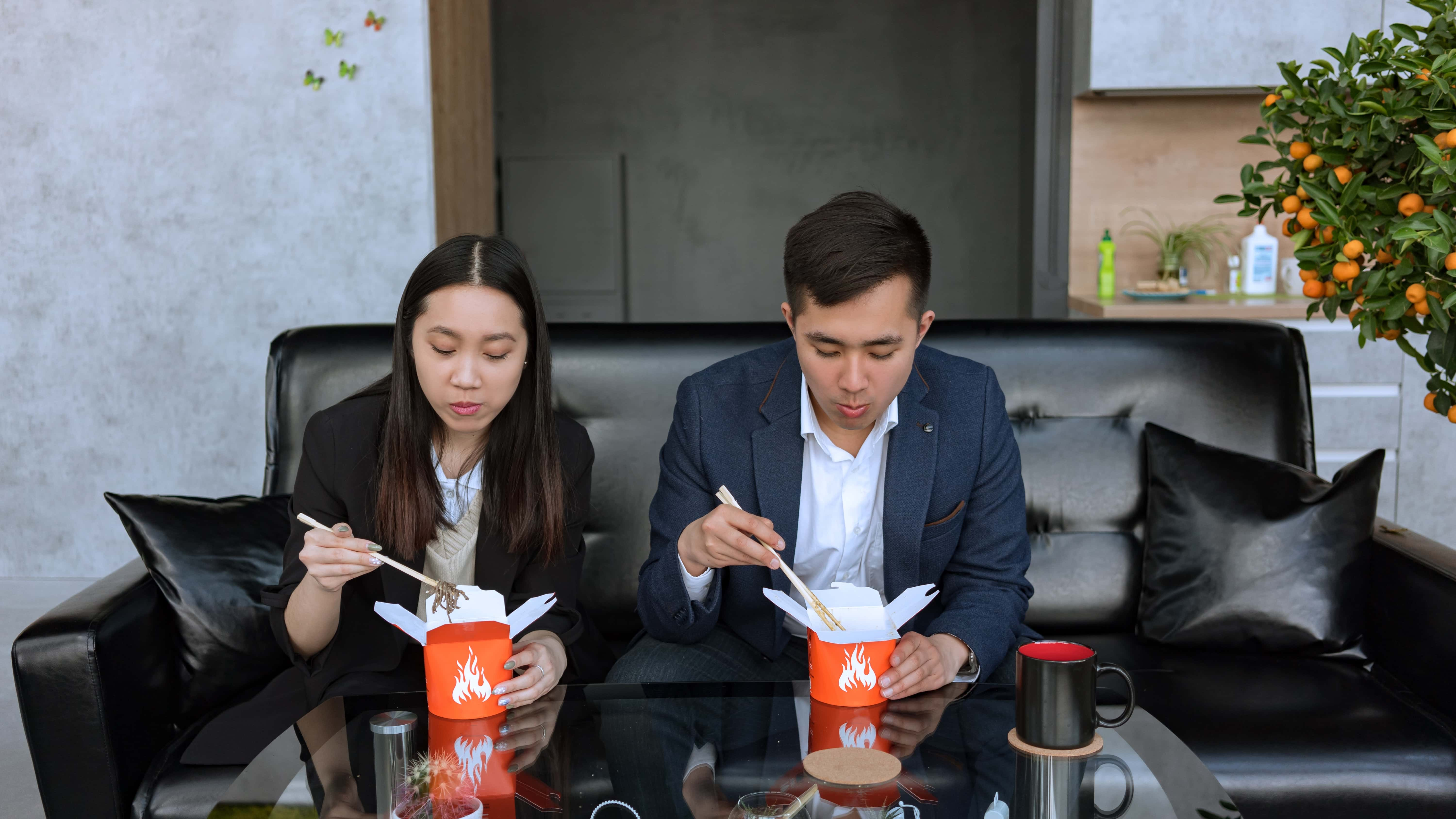 Photo by Mikhail Nilov: https://www.pexels.com/photo/man-and-woman-sitting-on-black-couch-eating-food-on-a-takeout-box-with-chopsticks-8102228/