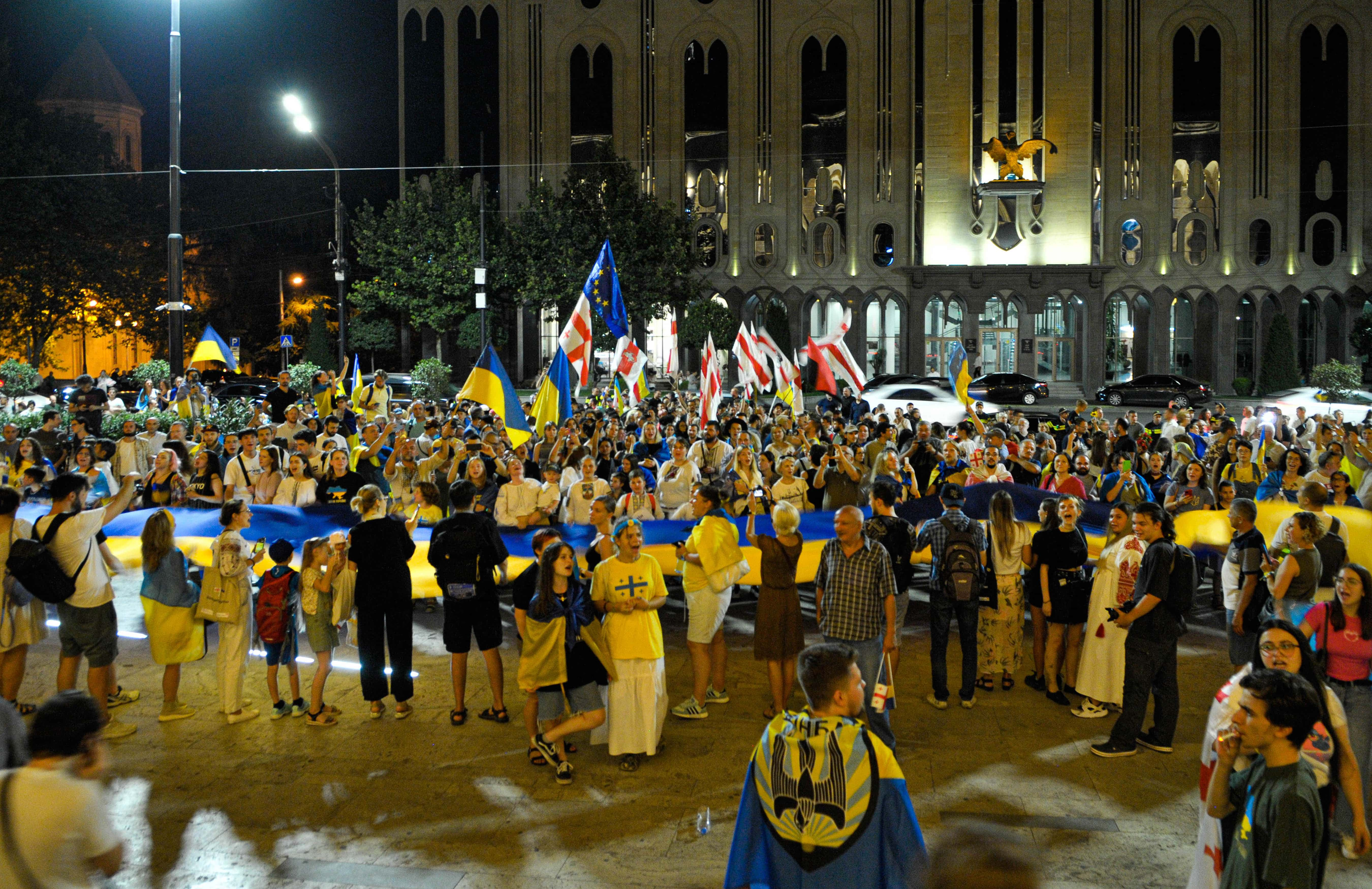 Image Source: Ukrainian refugees celebrate Ukraine Independence Day in front of the Georgian parliament on August 24, 2023 in Tbilisi, Georgia. Independence Day of Ukraine is celebrated on August 24 (Photo by Nicolo Vincenzo Malvestuto/Getty Images)