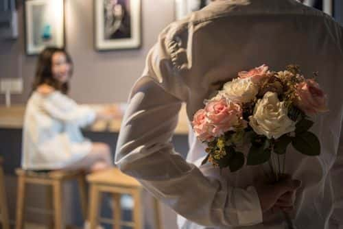 Wedding couple - Man surprises his mate with a flower. ( Getty Images /Nattachart Jerdnapapunt)