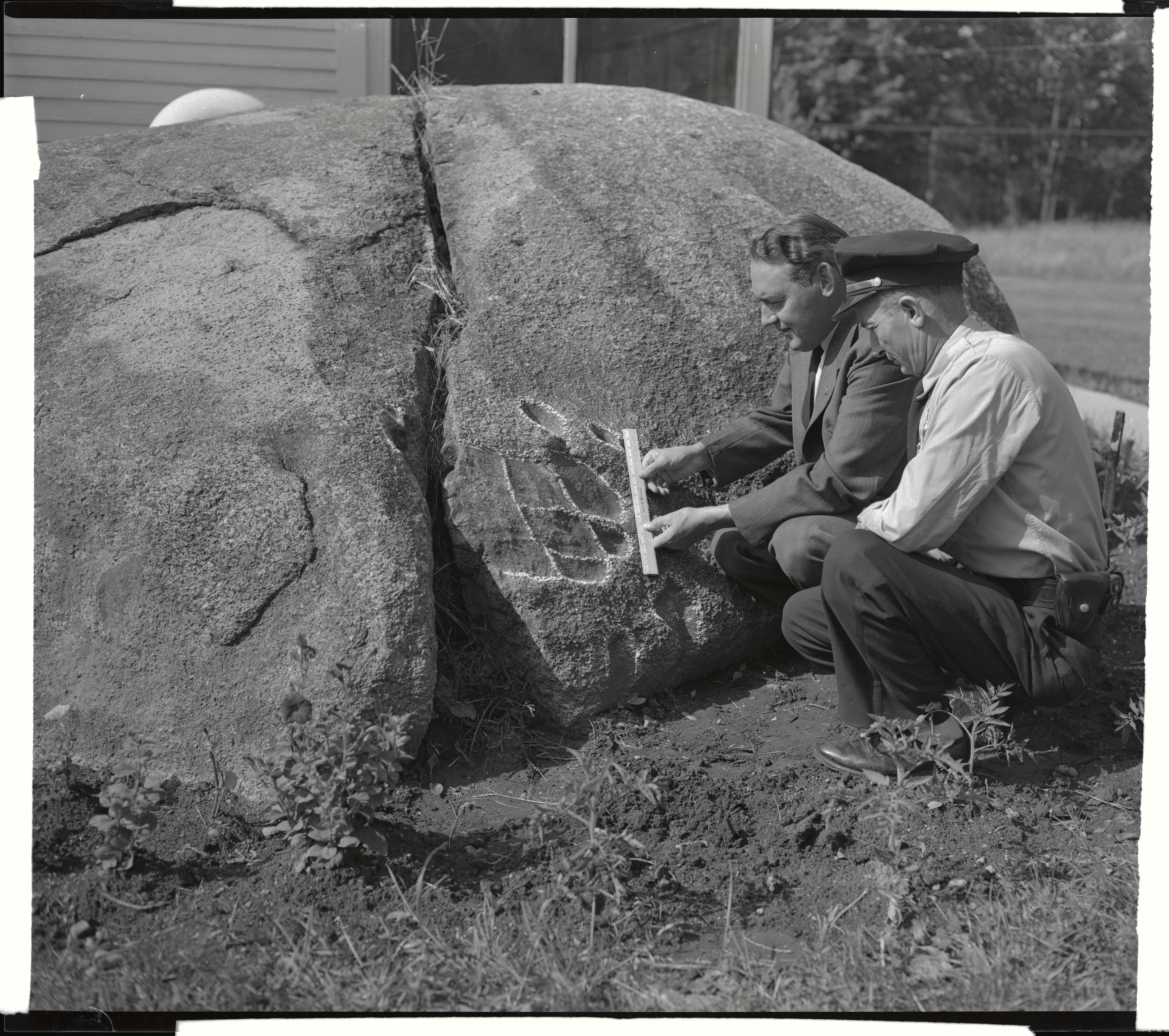  George T. Noyles,a Bethlehem town official, and police chief Howard Sanborn (right), measure the chalked outline of an impression in rock, believed to be a footprint made by an ancient dinosaur. The print, probably thousands of years old, is in near-perfect shape. It was discovered on a farm near Bethlehem. (Photo by © Bettmann/CORBIS/Bettmann Archive)