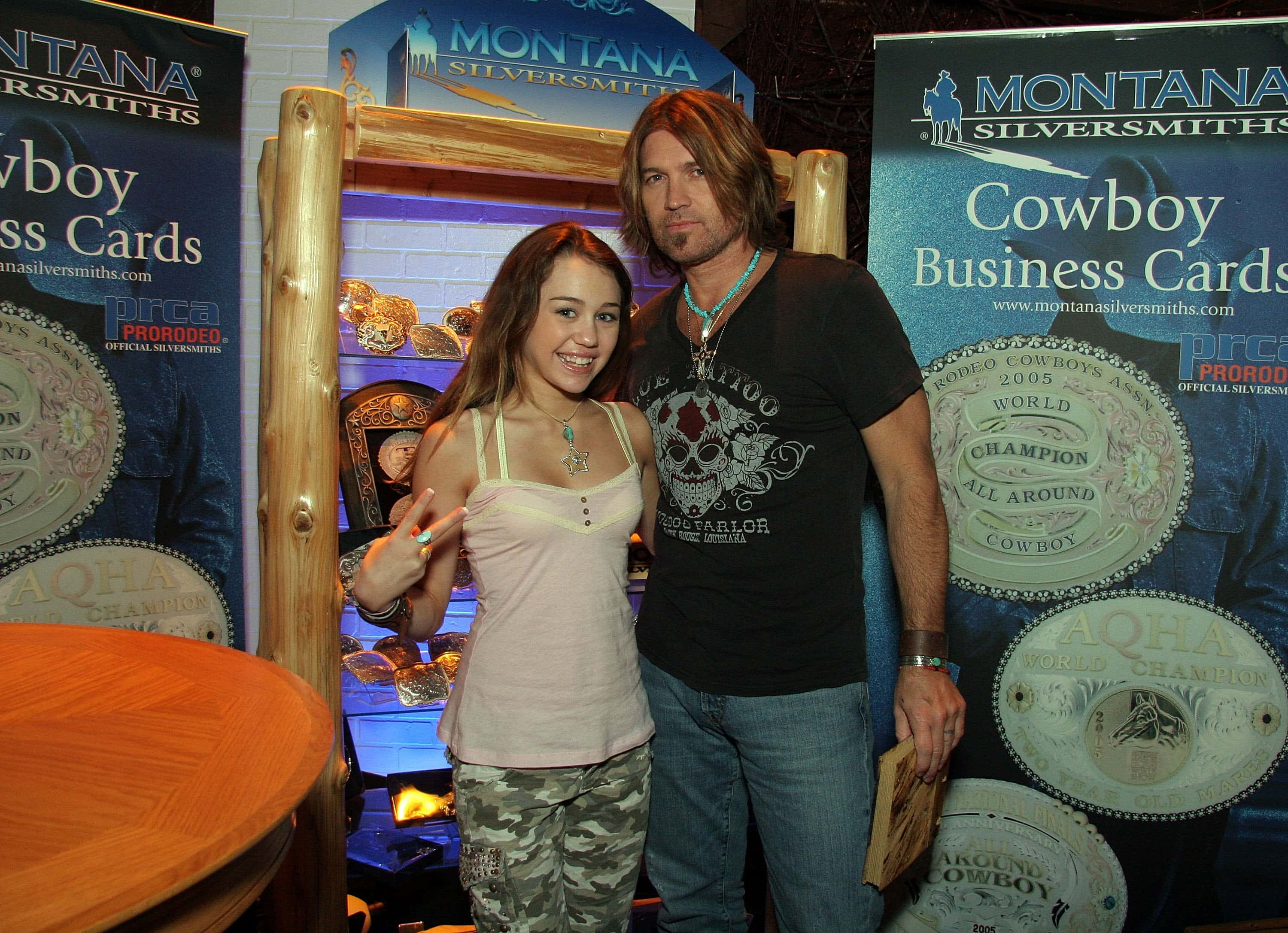 Actress Miley Cyrus (L) and Musician Billy Ray Cyrus pose with the Montana Silversmiths display at Distinctive Assets during the Academy of Country Music Awards held at the MGM Grand Garden Arena on May 23, 2006 in Las Vegas, Nevada. (Photo by Marsaili McGrath/Getty Images for Distinctive Assets)