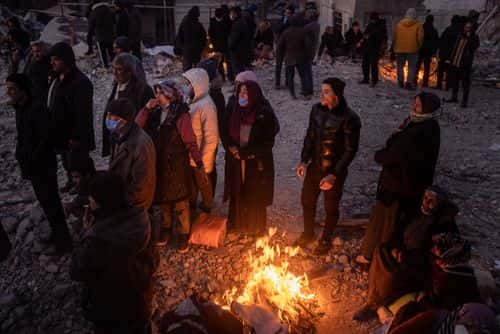 ADIYAMAN, TURKEY - FEBRUARY 12: Friends and relatives wait by fires as they watch rescue teams search a destroyed building on February 12, 2023, in Adiyaman, Turkey. A 7.8-magnitude earthquake hit near Gaziantep, Turkey, in the early hours of Monday, followed by another 7.5-magnitude tremor just after midday. The quakes caused widespread destruction in southern Turkey and northern Syria and killed more than 30,000 people. (Photo by Chris McGrath/Getty Images)